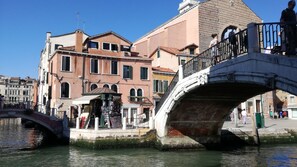 Un puente histórico sobre un canal, flanqueado por edificios a ambos lados.
