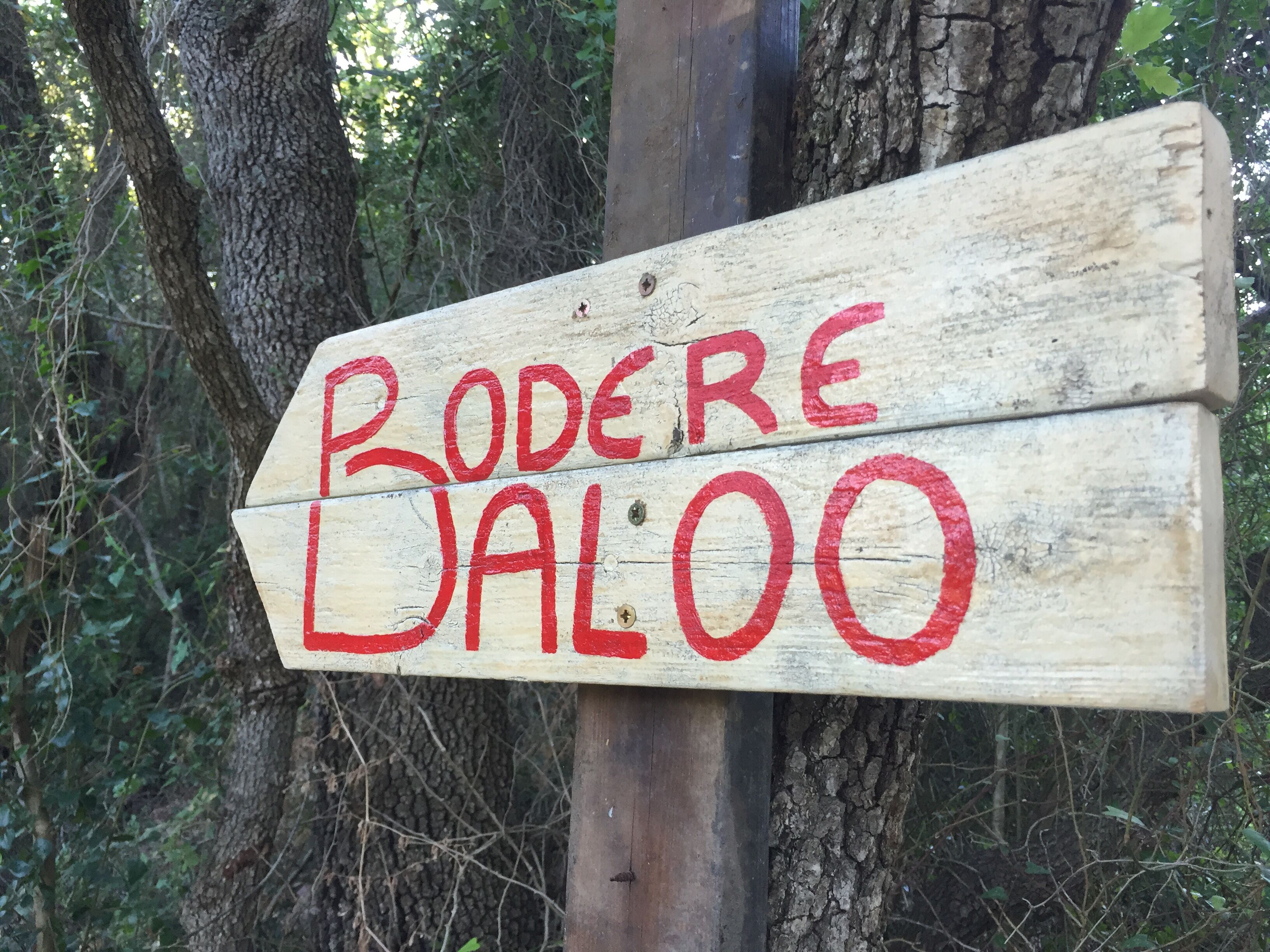 Un letrero de madera con el texto 'Bodere Dalo' escrito en rojo.