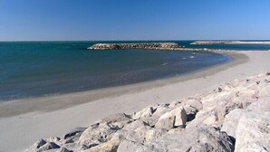 A beach with a rocky shoreline and calm waters.