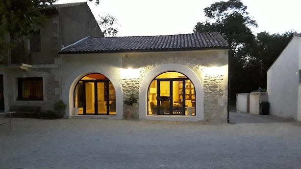 A building with two arched windows and a gravel courtyard.