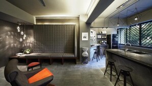 A modern interior with a seating area, bar, and large windows. - Campbell Inn - Hostel (Singapore)