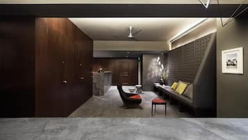 Un intérieur moderne comprenant un coin salon avec un canapé, un fauteuil et une petite table.