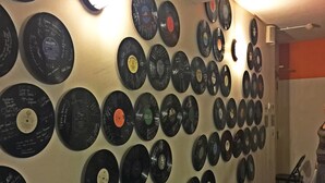 Un mur recouvert de disques vinyle disposés selon un motif en grille.