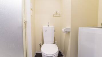 A small, clean bathroom with a white toilet, a towel rack, and a toilet paper holder.