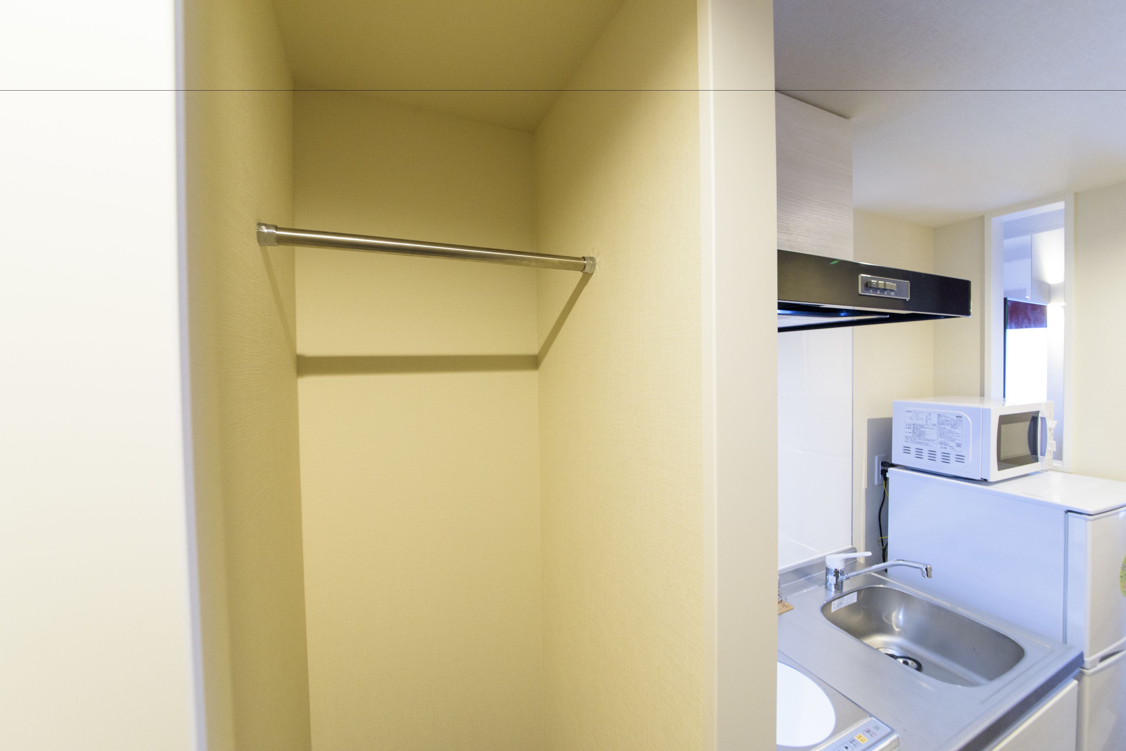 Un baño con perchero, lavabo y microondas.