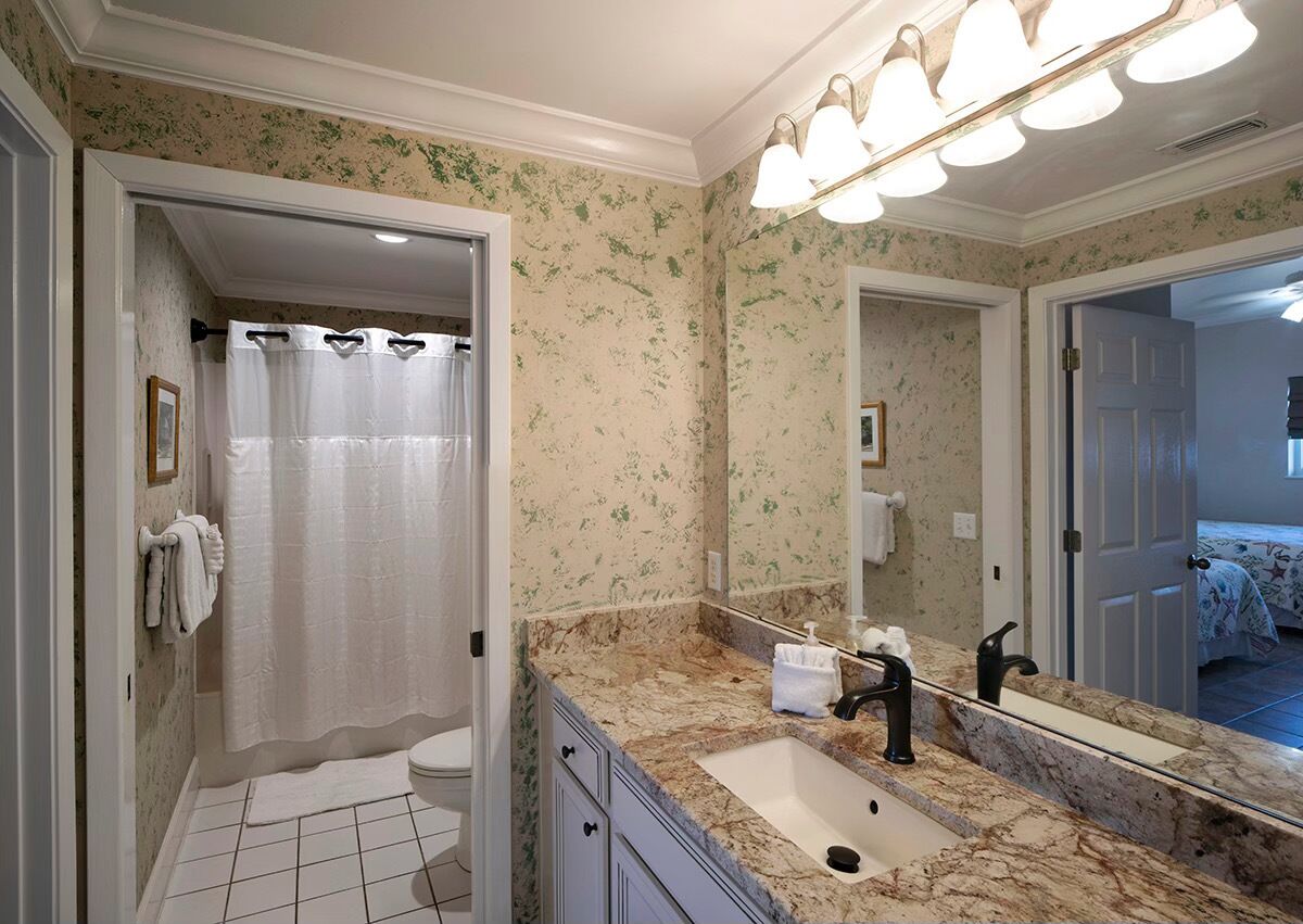 Un baño con inodoro, lavabo y cortina de ducha.