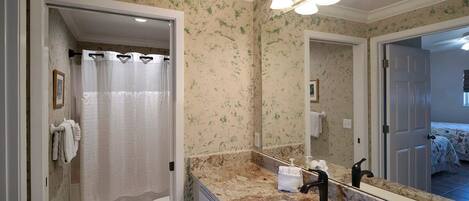 Un baño con inodoro, lavabo y cortina de ducha.