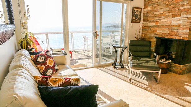 A living room with a white leather sofa, a green armchair, and a fireplace. - Stunning Multimillion Dollar Whitewater -interior by Artist- special 2026 prices (Dana Point)