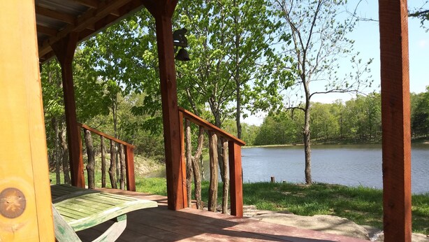 A wooden deck with a railing overlooking a lake, surrounded by trees. - The Lily Pad, headwaters of Eden Falls (Ponca)