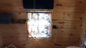 A small, cozy room with a bed, a table, and a ceiling fan. - The Lily Pad, headwaters of Eden Falls (Ponca)