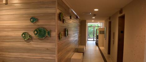 A hallway with wooden paneling and a bench.