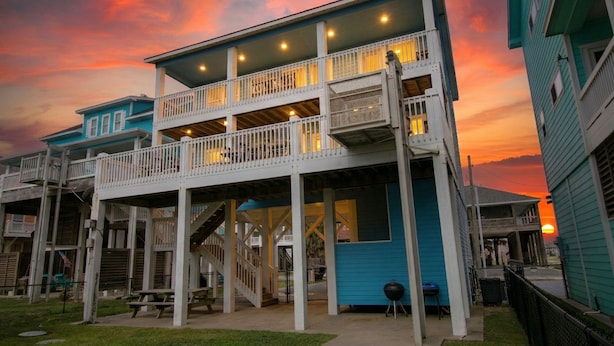 A two-story building with a balcony and a staircase leading to the upper floor.