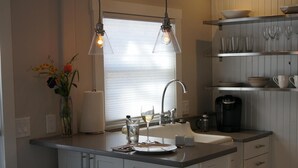Een moderne keuken met een centraal eiland, hanglampen en barkrukken.