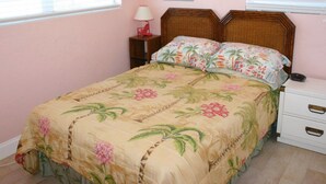 A bedroom with a bed, a nightstand, a lamp, and a painting on the wall.