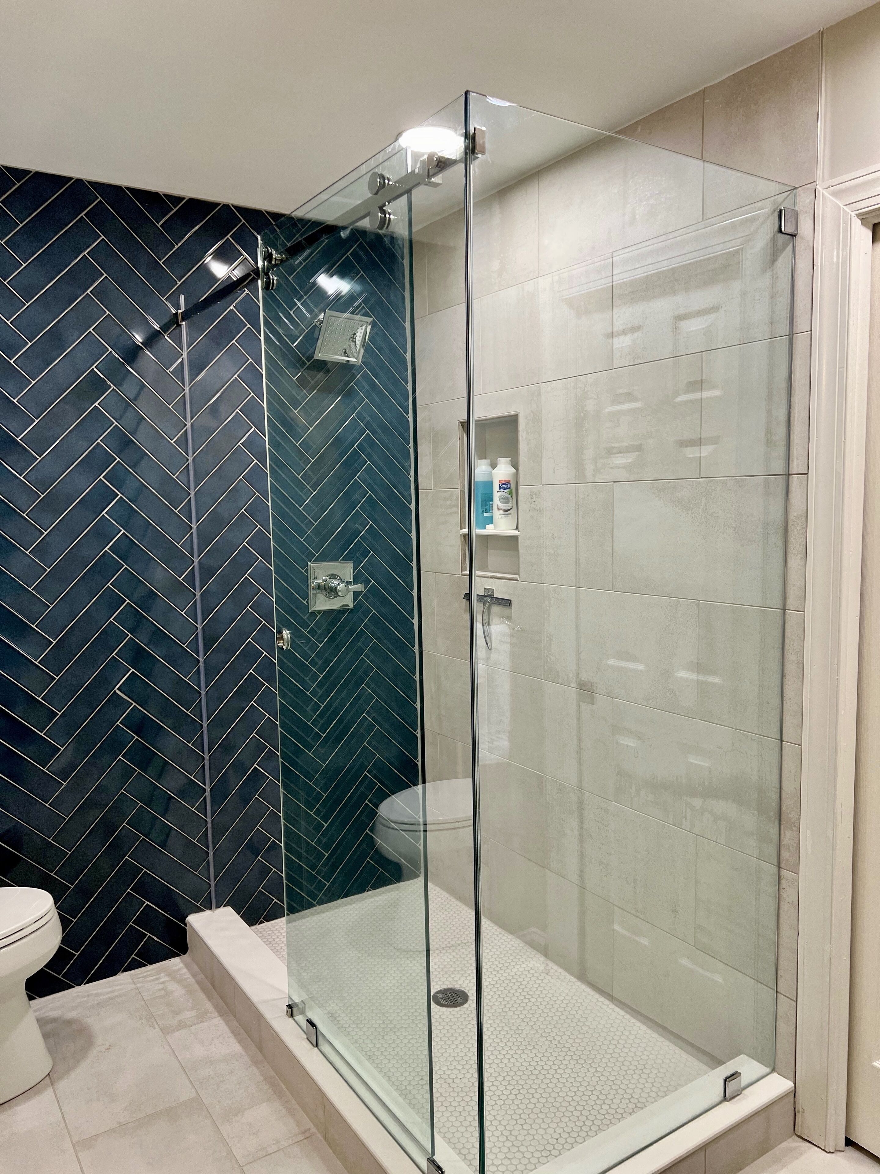 Un baño moderno con ducha de vidrio, inodoro y lavamanos.