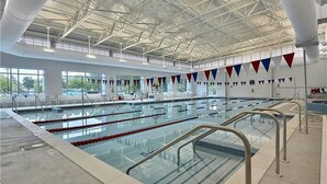 An indoor swimming pool with multiple lanes, clear water, and a high ceiling with visible structural beams. - Sea Colony West - 2BR, 2BA - 1 Block to Tennis Center, 1/2 Mile to Beach (Bethany Beach)