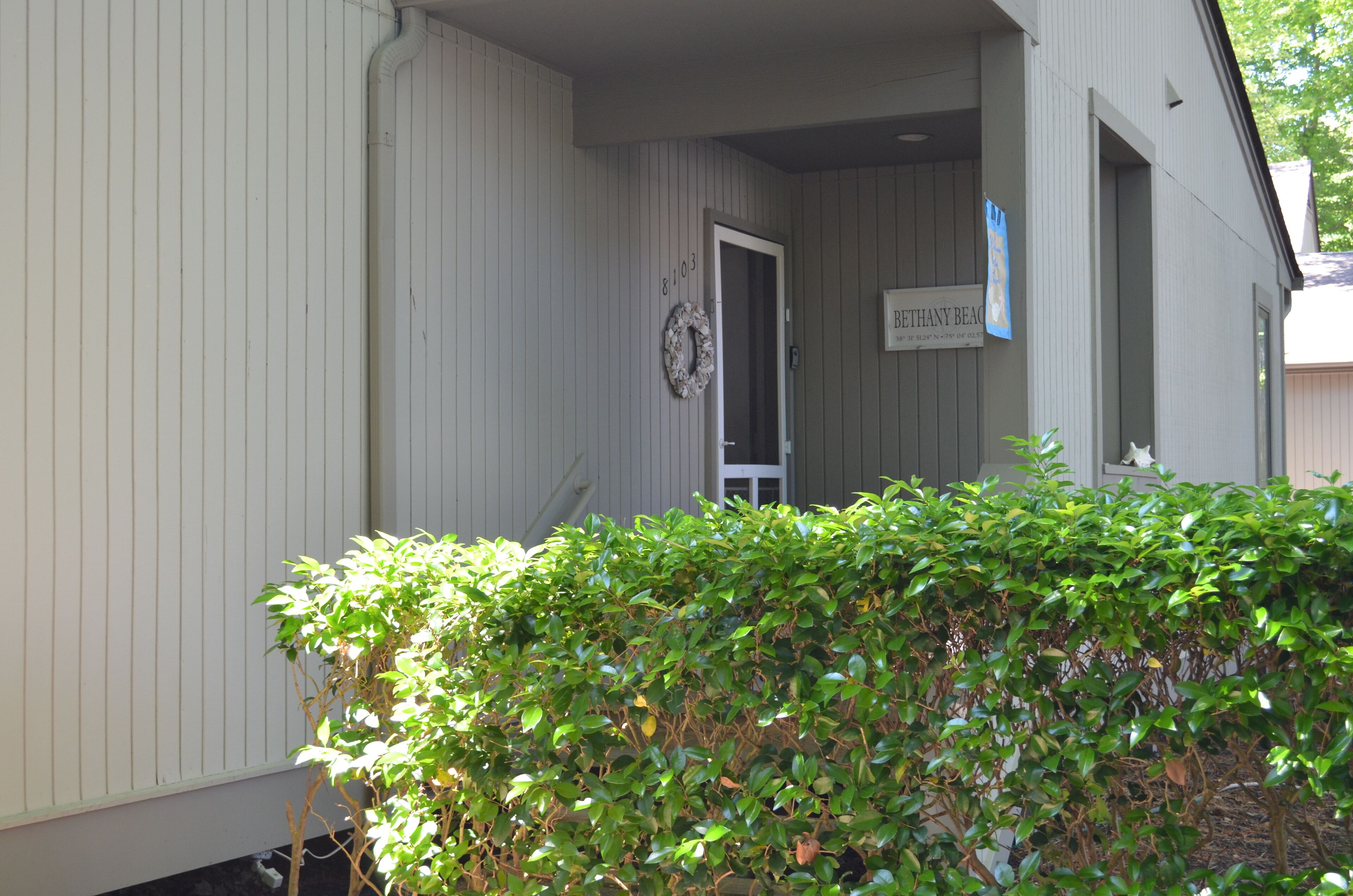 A building with a door leading to a covered porch area.