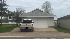 A white pickup truck parked in front of a single-story house with a garage.