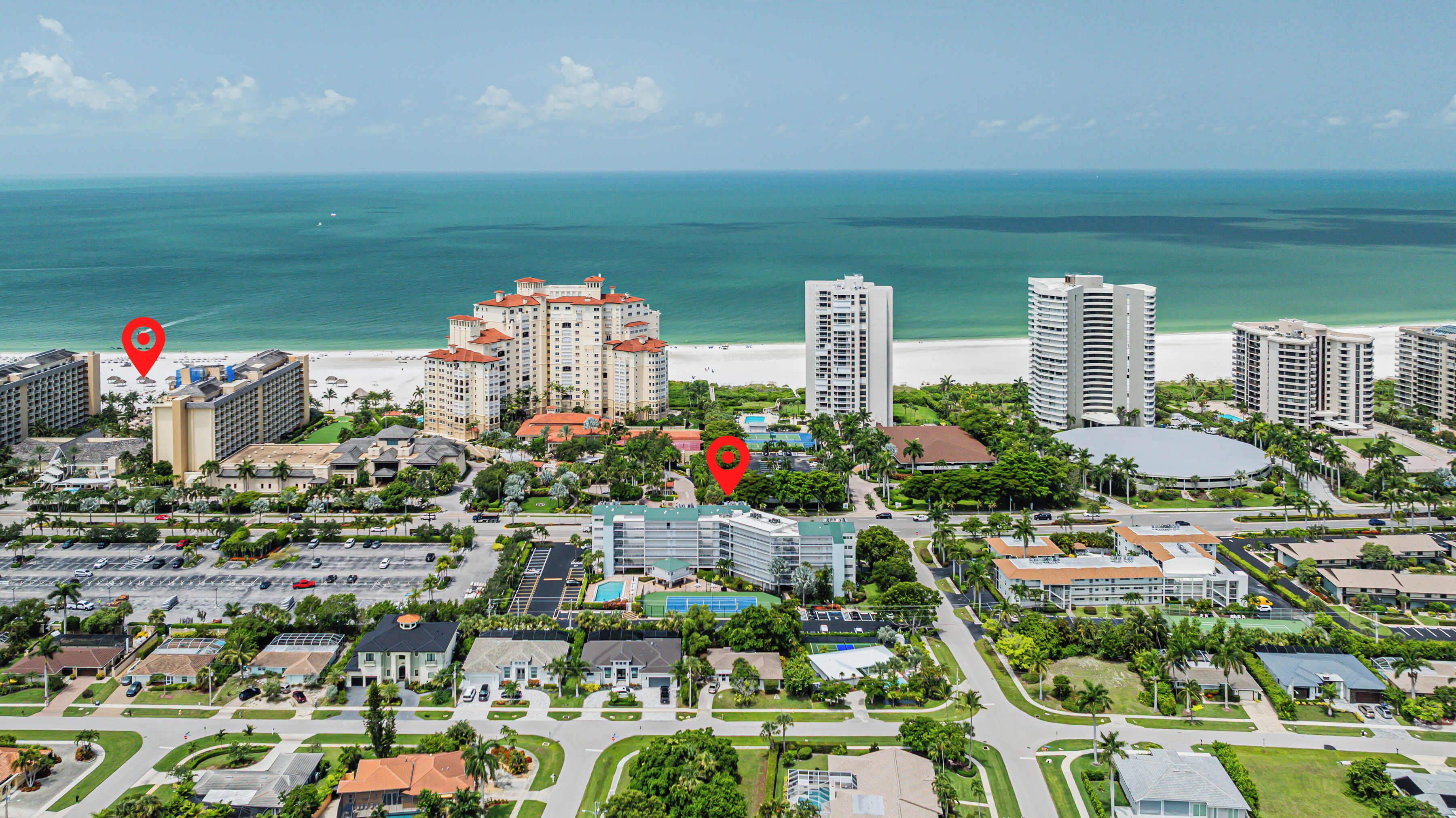 A coastal cityscape with high-rise hotels, a beach, and a golf course.