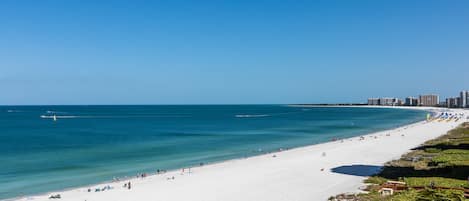 Perto da praia, espreguiçadeiras, guarda-sóis, toalhas de praia 