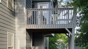 A two-story house with a covered patio area featuring a round table and four chairs. - SPACIOUS Cartersville HOME that SLEEPS UP TO 13 PEOPLE and 12 min. to Lakepoint! (Cartersville)