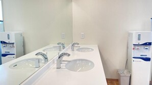 A modern bathroom with three sinks, a mirror, and a water dispenser. - Sabae Dai-ichi Hotel (Sabae)