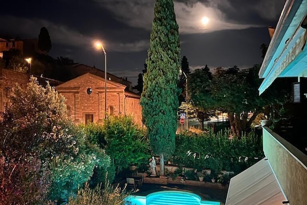 Een seizoensgebonden buitenzwembad, ligstoelen bij het zwembad