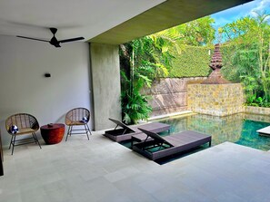 Una piscina al aire libre, sillones reclinables de piscina