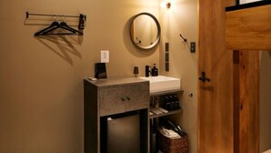 Une salle de bain compacte avec un lavabo intégré, un miroir, un porte-serviettes et un petit meuble de rangement.