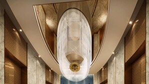 Ein großzügiger Korridor mit einem imposanten, verzierten Chandelier, Marmorwänden und einer zentralen Kunstausstellung.