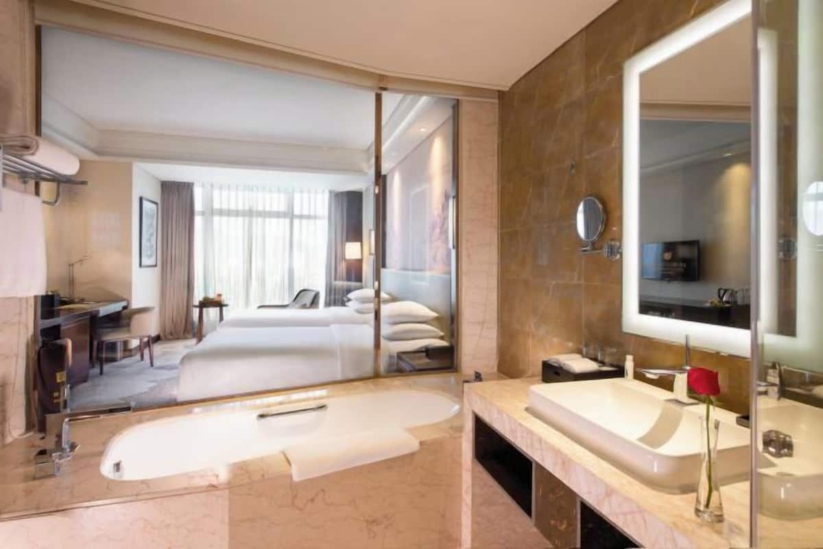 Ein modernes Badezimmer mit großem Spiegel, einer Badewanne und einem Waschbecken.
