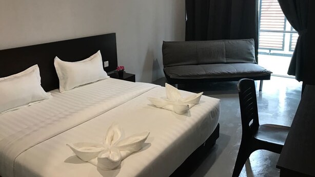 Habitación de hotel con una cama, un sofá y una silla.