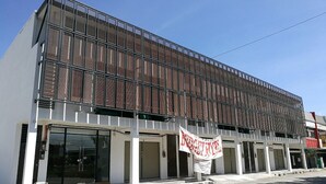 Un edificio moderno con fachada de metal y ventanas amplias.