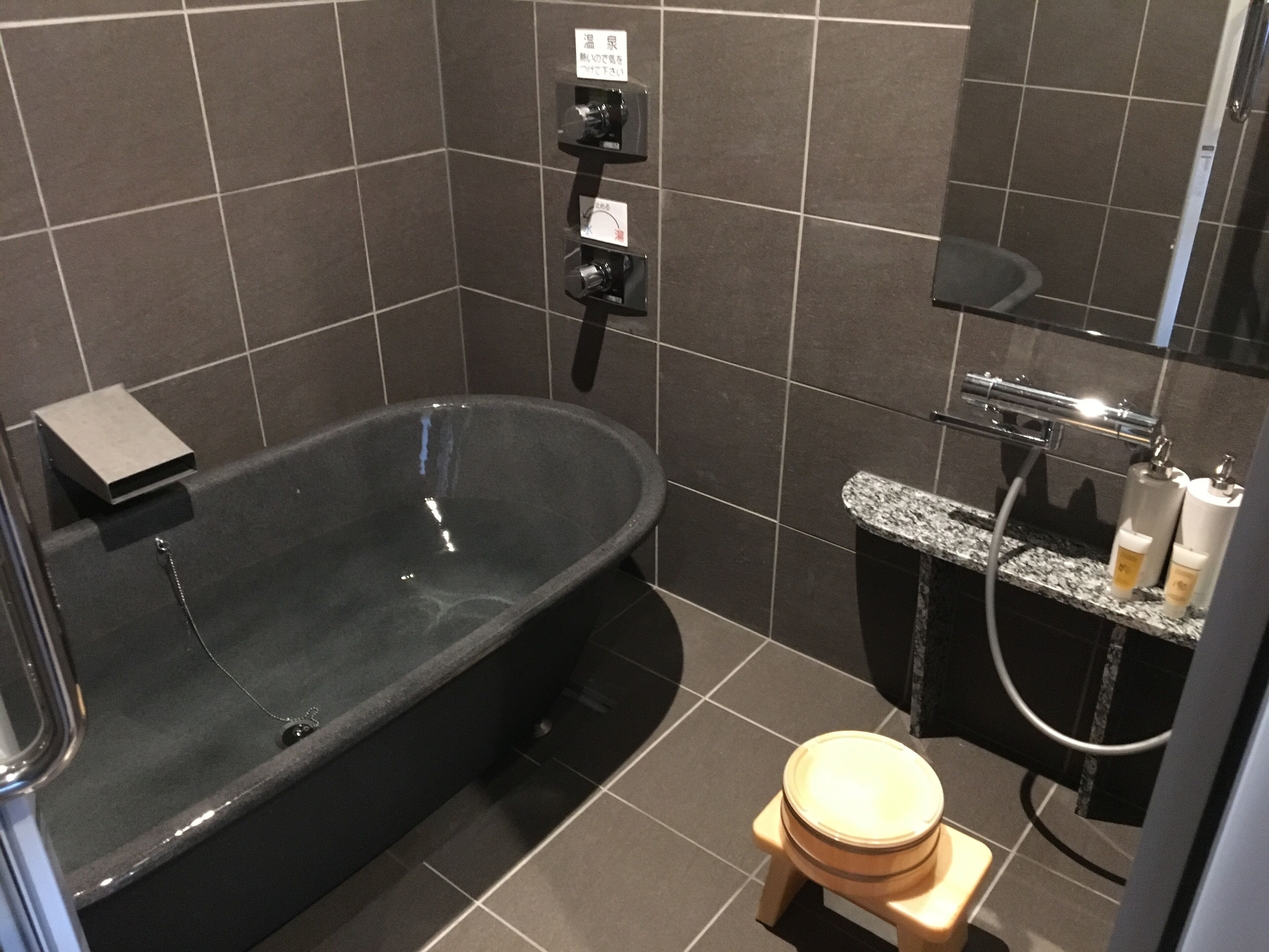 Een moderne badkamer met een vrijstaand bad, toilet en douche.