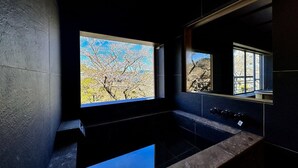 Un baño moderno con un ventanal grande, un lavamanos y un espejo.