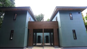 A modern building with a symmetrical facade, large windows, and a central wooden entrance. - Tabinoteitaku Okinawa Bise Homann Concept (Motobu)