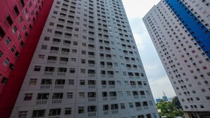 Un edificio alto de varios pisos con una fachada uniforme, con ventanas y balcones distribuidos regularmente.