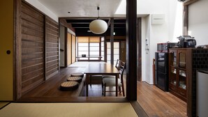 A traditional Japanese-style room with tatami flooring, a low table with cushions, and a sliding door. - Tachibana an (Kyoto)