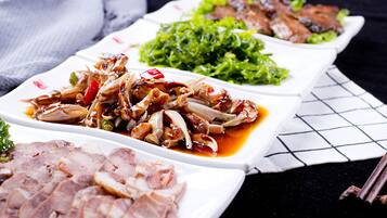 Variedad de platos que incluyen carne en rodajas, verduras salteadas y hojas verdes.
