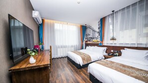 A hotel room with two beds, a wooden desk, a flat-screen TV, and a large window with curtains. - MG Hotel - St. Michael's Cathedral, Qingdao (Qingdao)