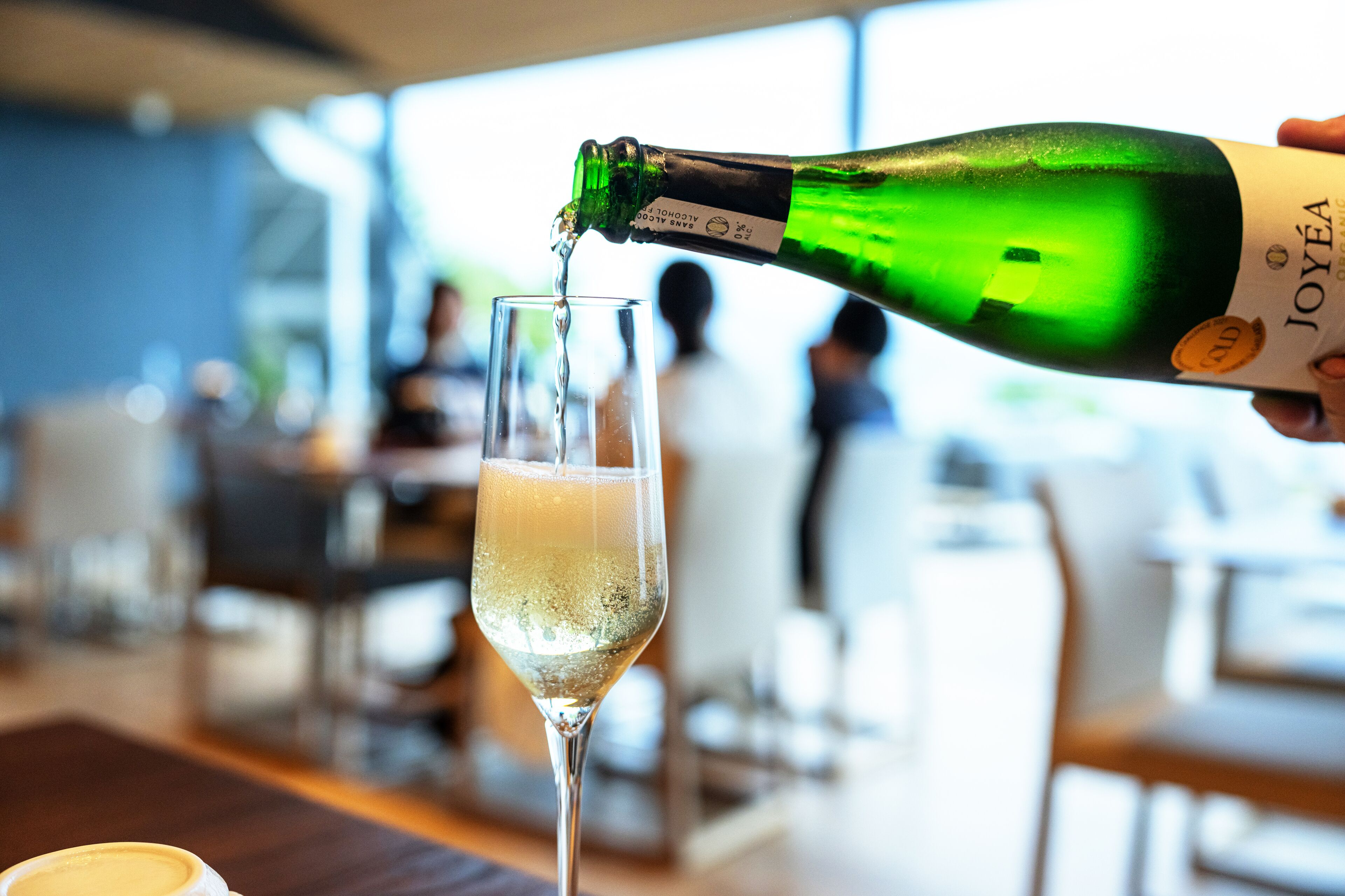 A bottle of champagne being poured into a glass.