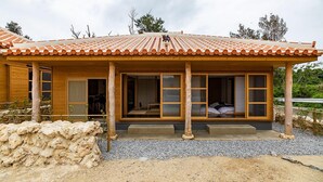 A traditional Japanese-style building with a tiled roof, wooden exterior, and a covered porch. - Tabinoteitaku OkinawaNakijin HOMANN CONCEPT (Nakijin)