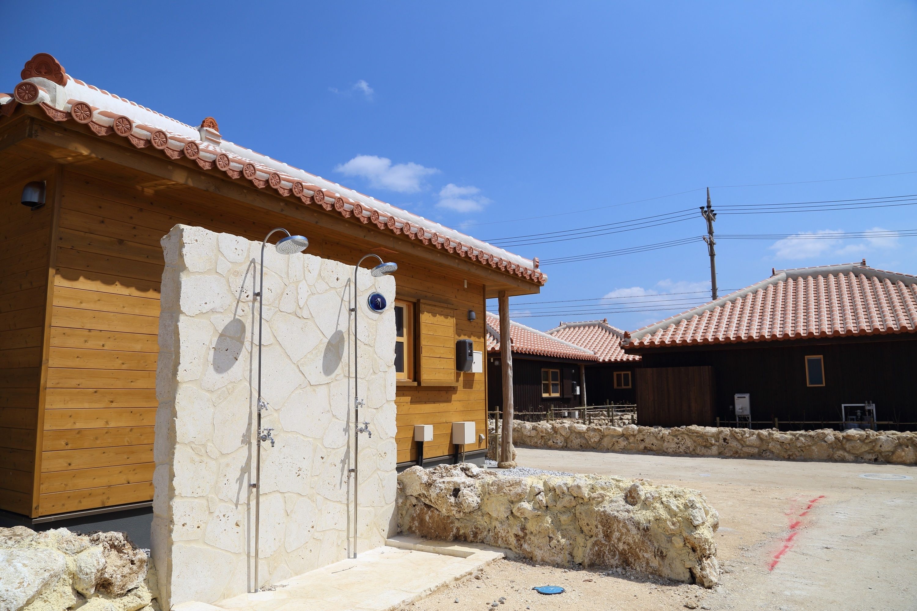 Un edificio rústico con entrada de pared de piedra, fachada de madera y tejado de tejas.