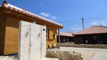 Un edificio rústico con entrada de pared de piedra, fachada de madera y tejado de tejas.