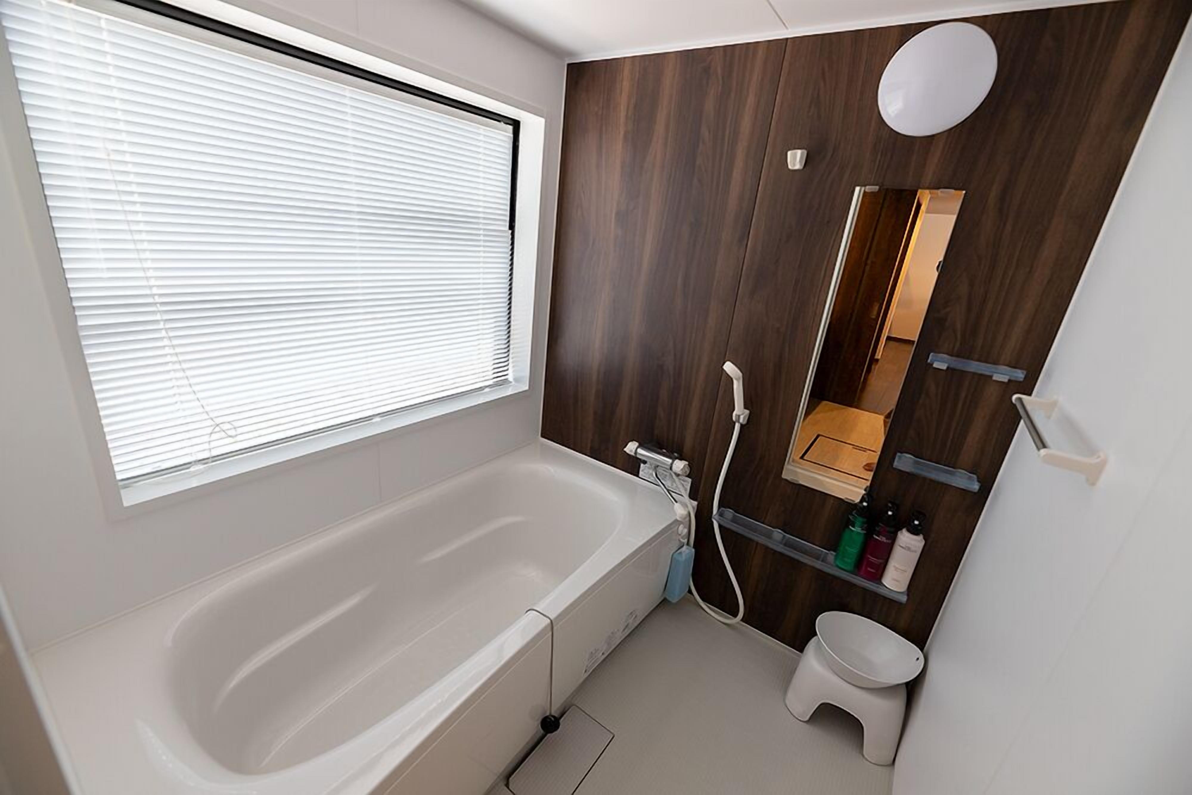 A modern bathroom with a bathtub, toilet, and a vanity with a mirror.
