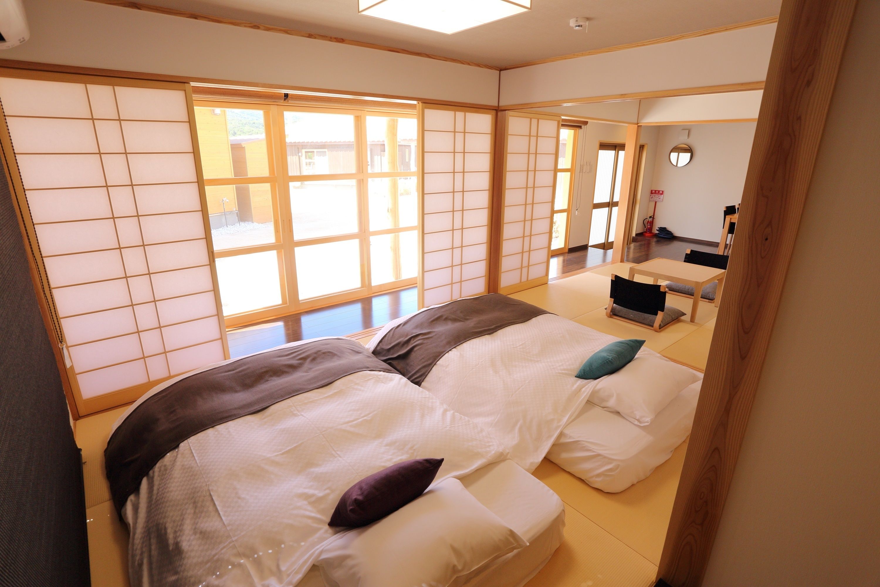 A traditional Japanese-style room with tatami flooring, a low table, and sliding doors.