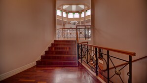 A staircase with wooden steps and a metal railing leading to a second-floor landing with a glass ceiling and windows. - The Round House ~Truly Unique ~ Sleeps 14 ~ Close to CBD and Mount Panorama!
 (Bathurst)