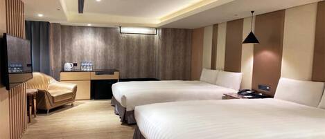 Habitación de hotel con dos camas, un escritorio, una silla y un televisor.