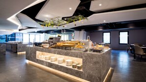 Un bar à petit-déjeuner moderne, doté de comptoirs en marbre et proposant une grande variété d’aliments.