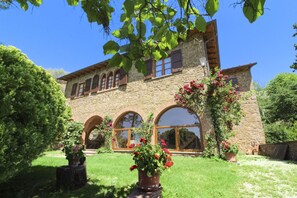 A stone building with arched windows and a garden with potted plants. - Beautiful villa with a splendid panoramic view over vineyards and olive groves. Ideal for visiting T (Monte San Savino)